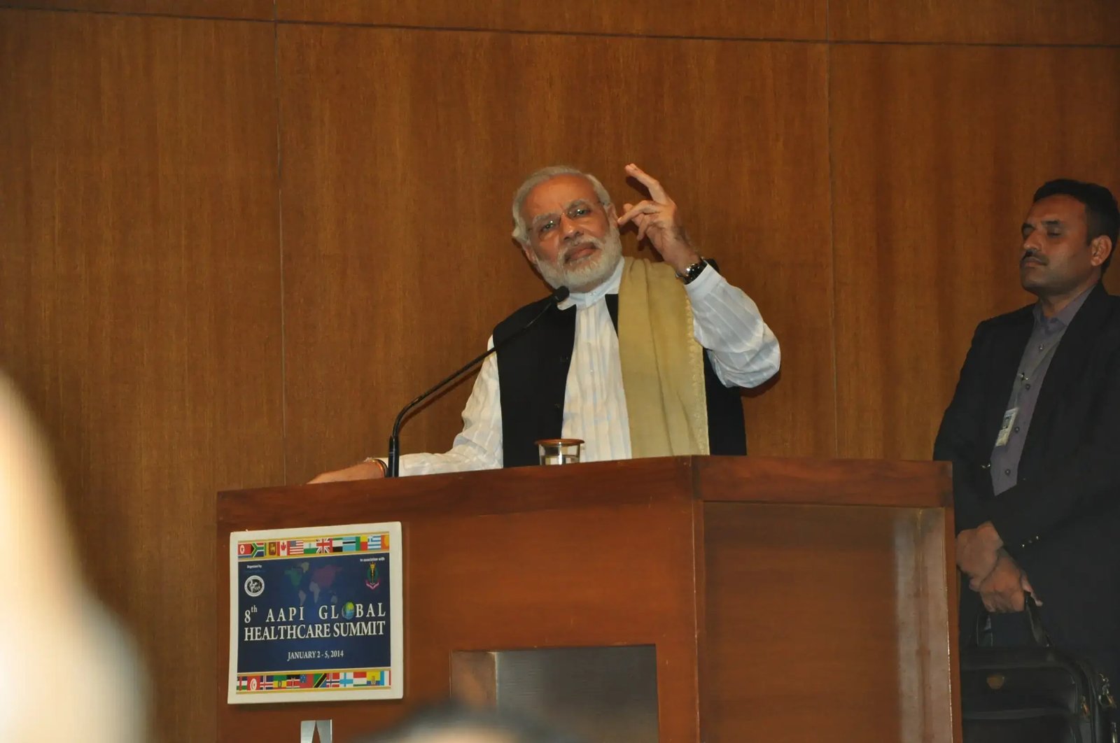 Balloon arch in orange, black, and white colors framing an ITT logo board lit with warm lights