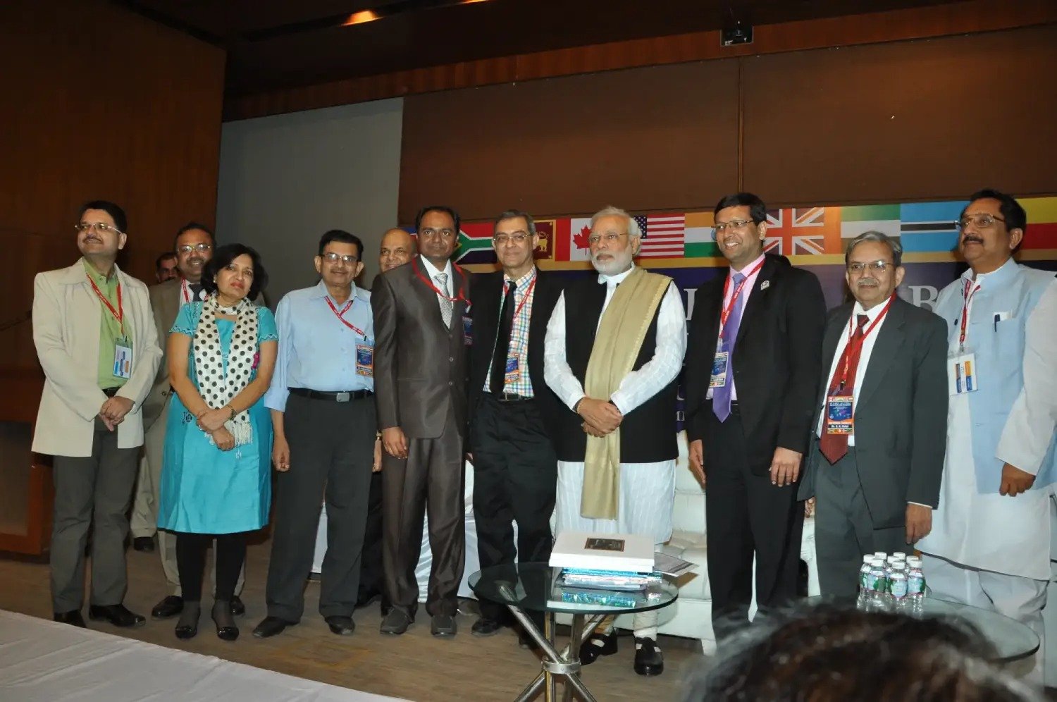 Men lighting ceremonial lamp at event with ITT banner in background