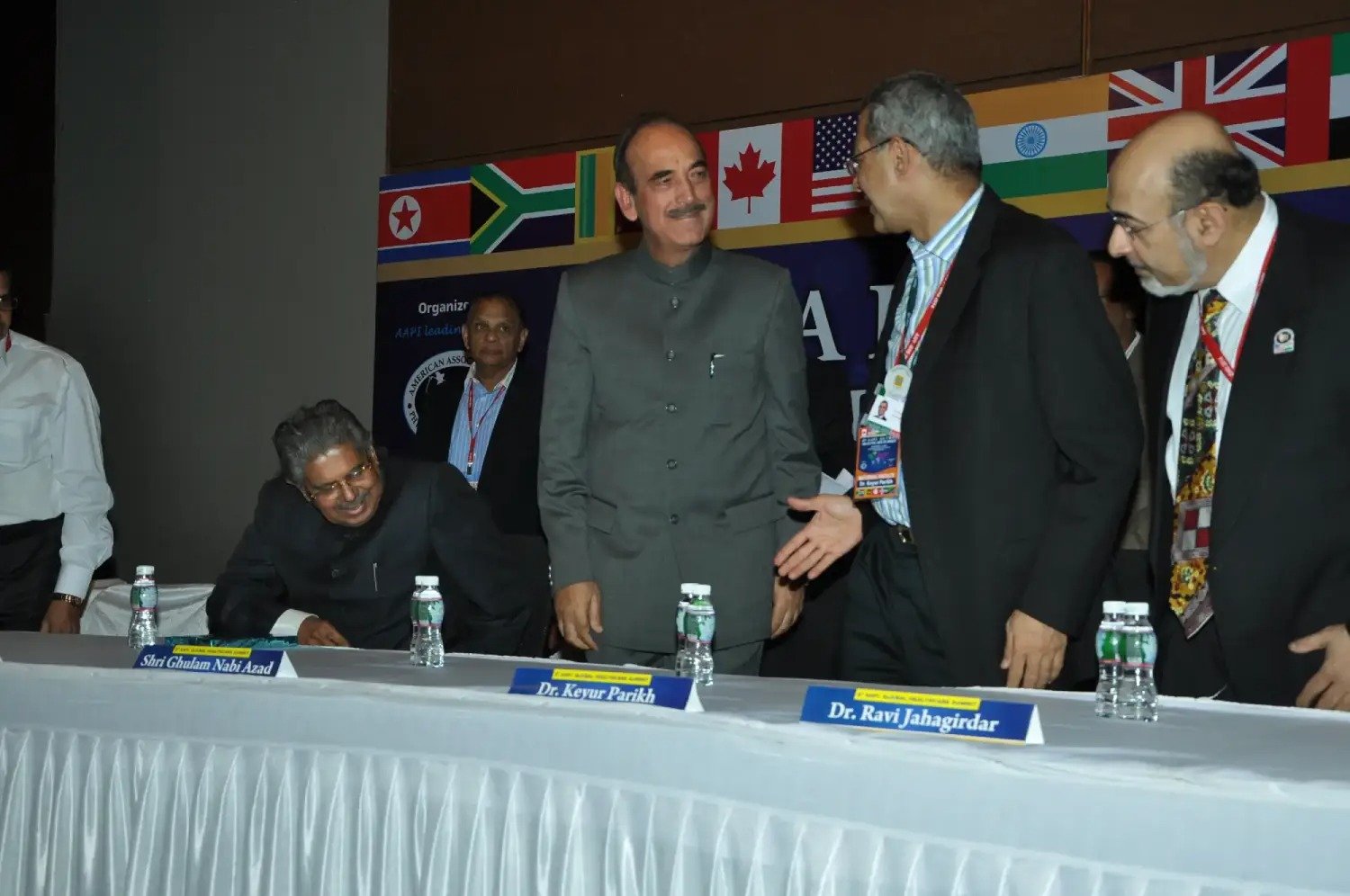 Man and woman speaking on stage at night with blue lighting