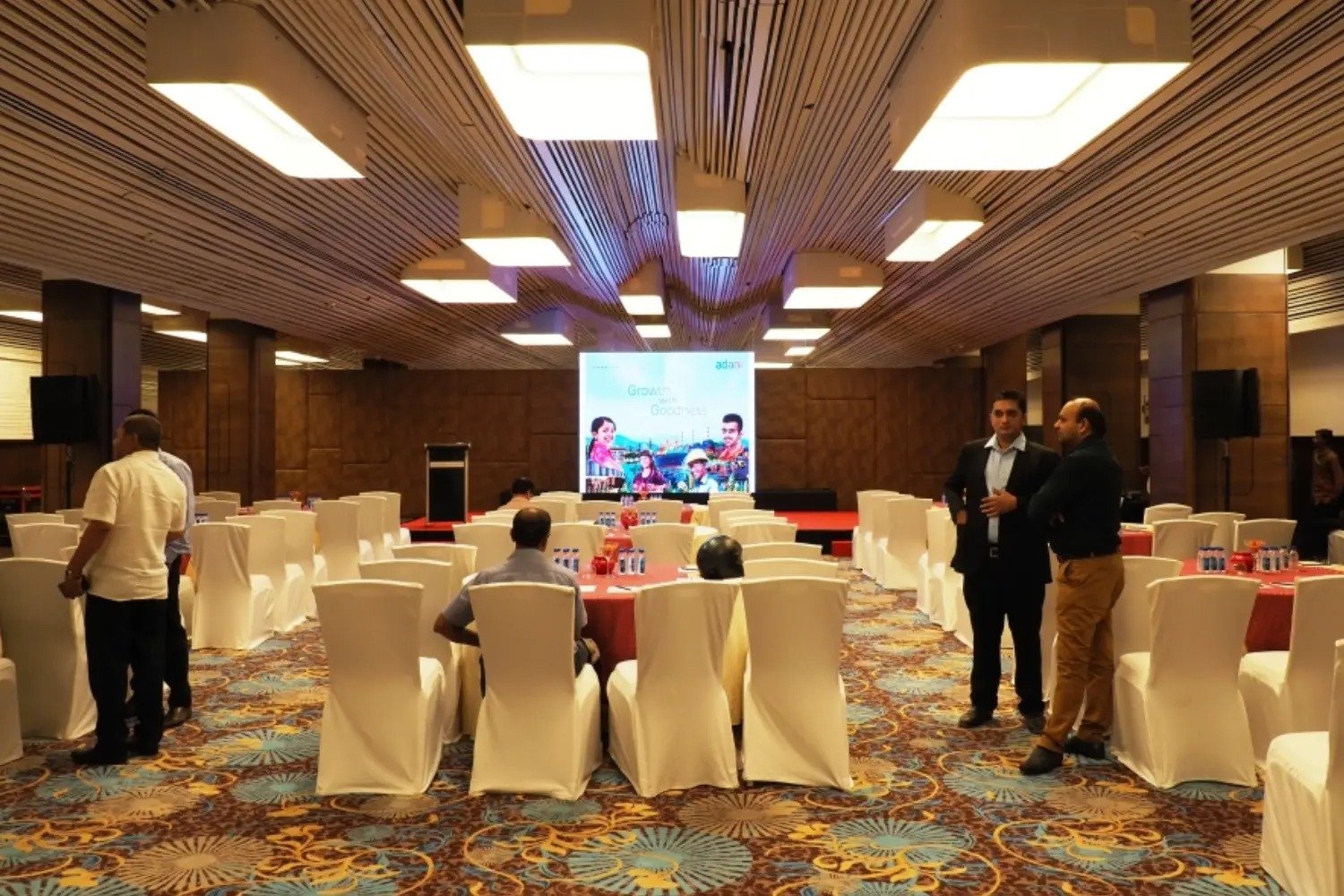 ITT event entrance with red and green carpet and pink lighting on white structure with ITT branding