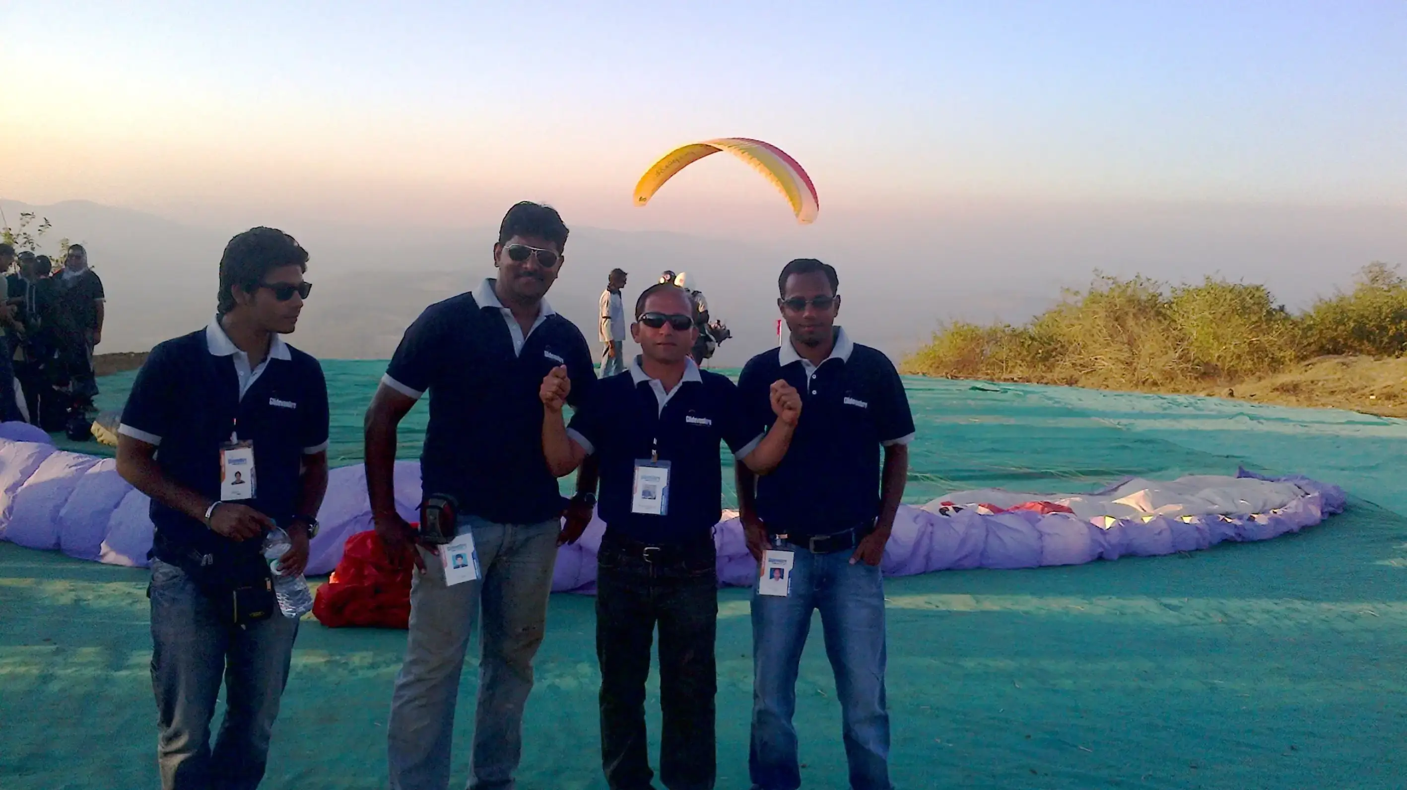 Balloon arch in orange, black, and white colors framing an ITT logo board lit with warm lights