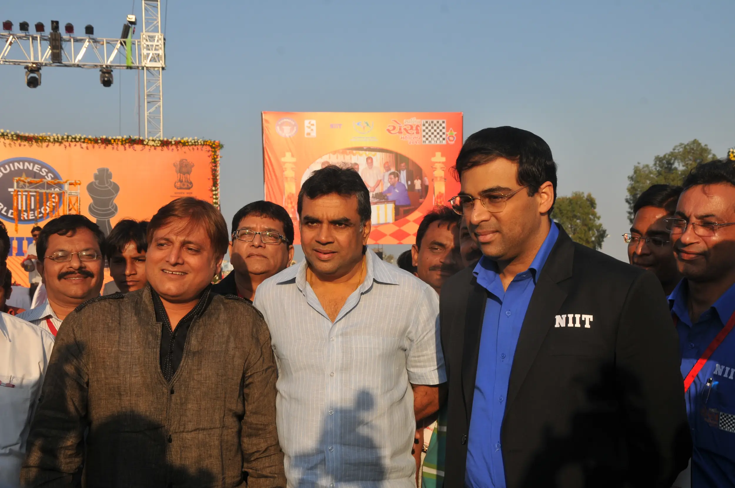 Men lighting ceremonial lamp at event with ITT banner in background