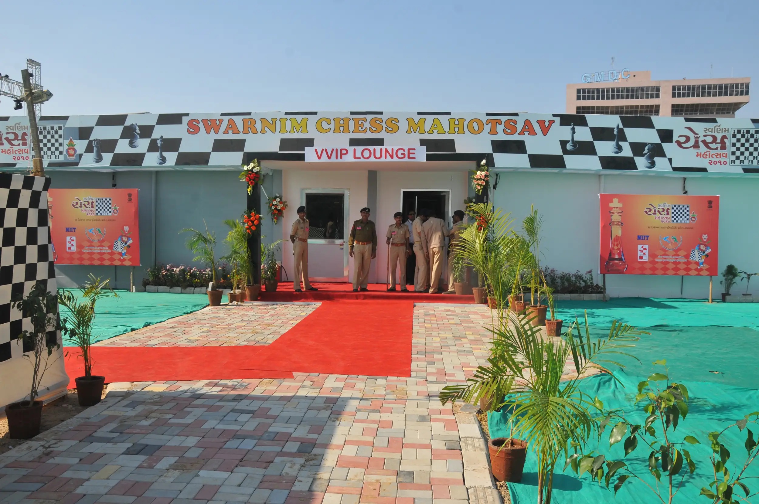Men lighting ceremonial lamp at event with ITT banner in background